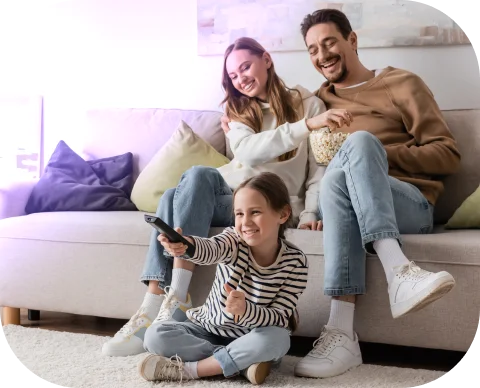Família no sofá assistindo TV, momento de conforto em casa com automação da Olli